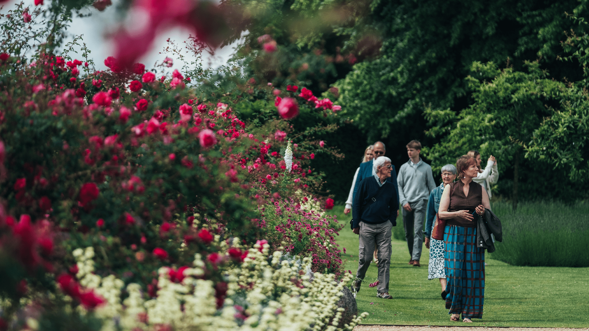 A group of people walking in a Nevill Holt garden