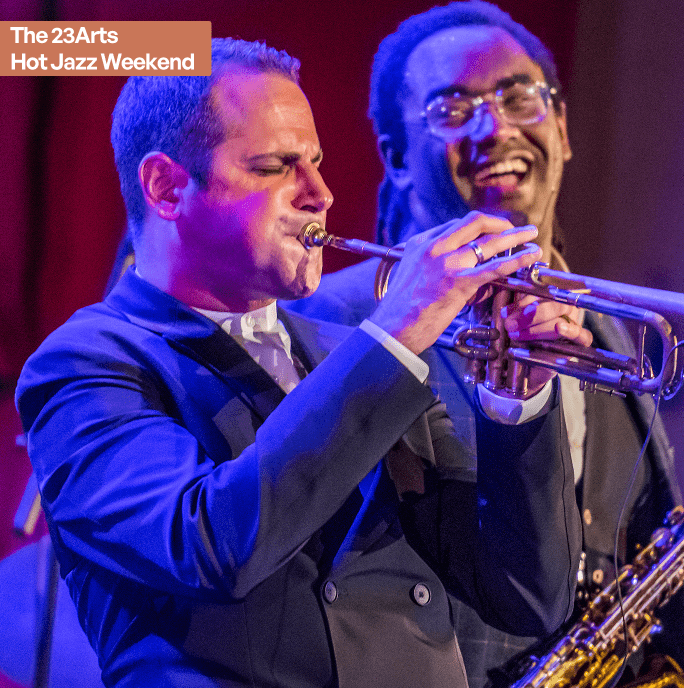 A night in Harlem. Two jazz musicians on a stage, one playing the trumpet the other smiling in the background