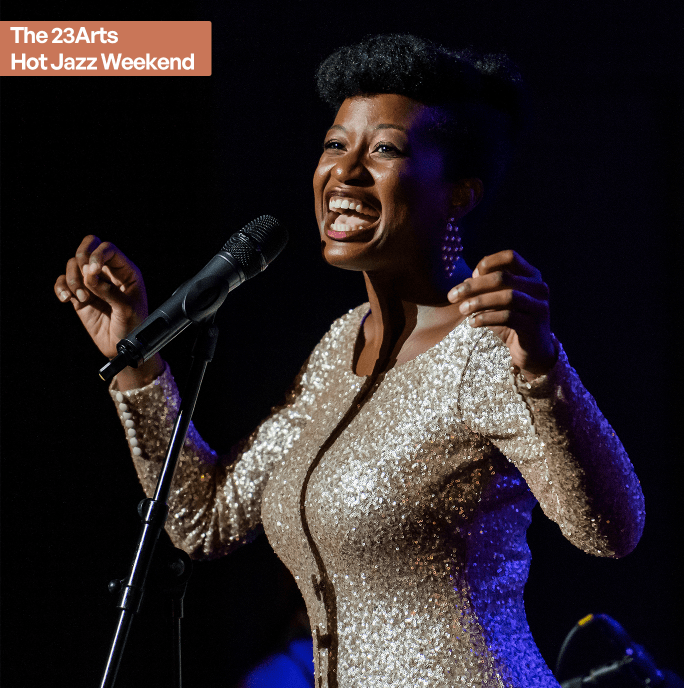 Ladies of the blues. A black female singer on a stage in a gold glitter dress standing behind a. microphone